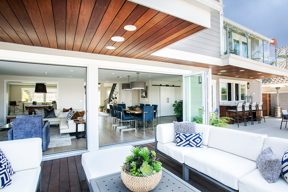 Idée de décoration pour une terrasse arrière design avec une cuisine d'été et une extension de toiture.