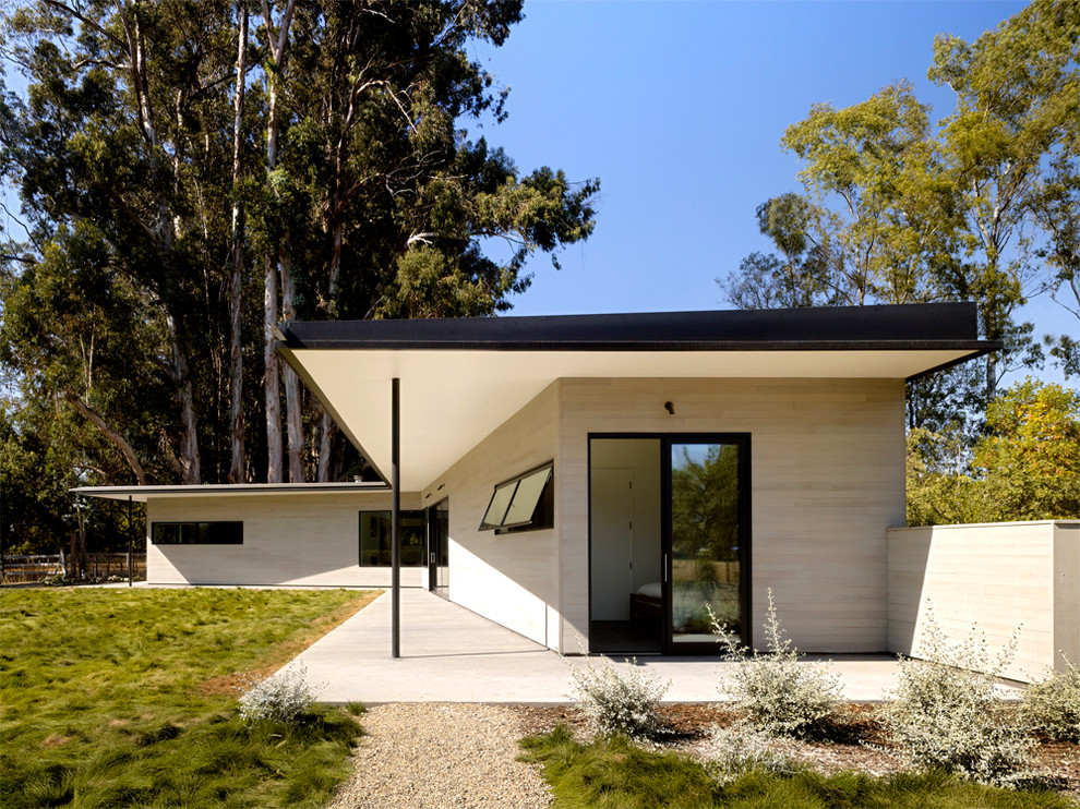 Esempio di un patio o portico minimalista dietro casa con lastre di cemento e un tetto a sbalzo