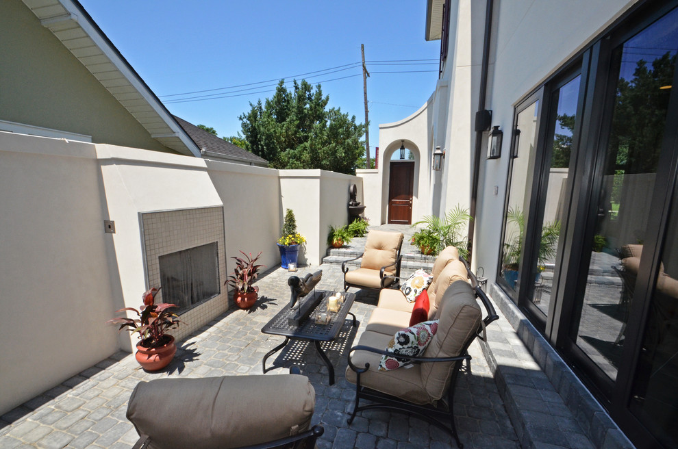 Medium sized classic side patio in New Orleans with brick paving, no cover and a fire feature.