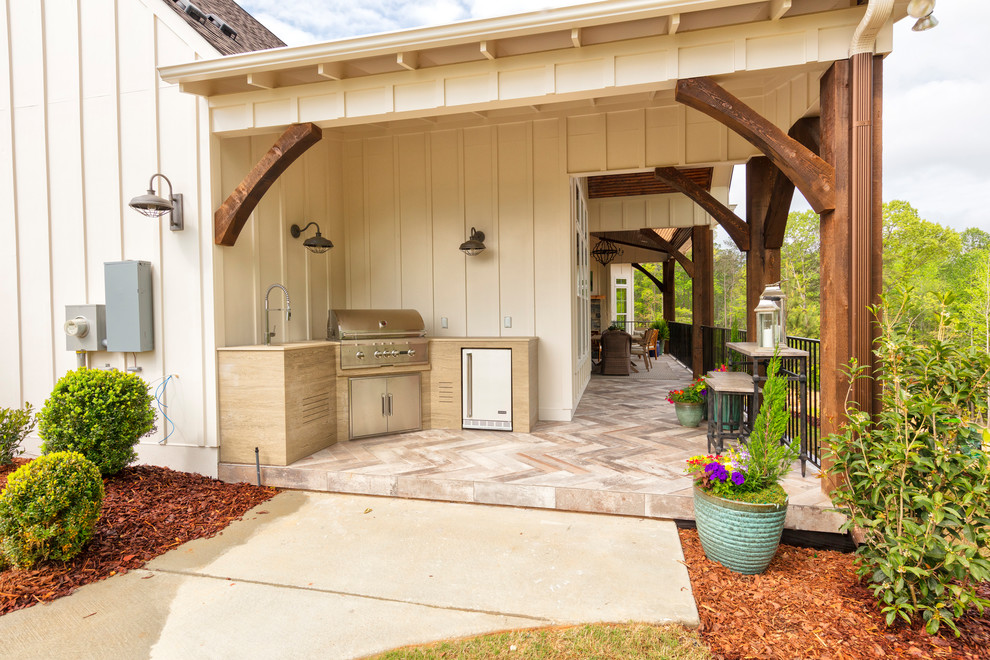 Foto di un patio o portico country di medie dimensioni e dietro casa con piastrelle e un tetto a sbalzo
