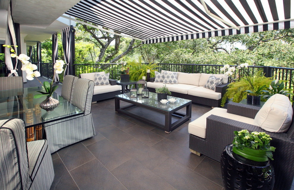 Immagine di un patio o portico minimal di medie dimensioni e dietro casa con piastrelle e un parasole