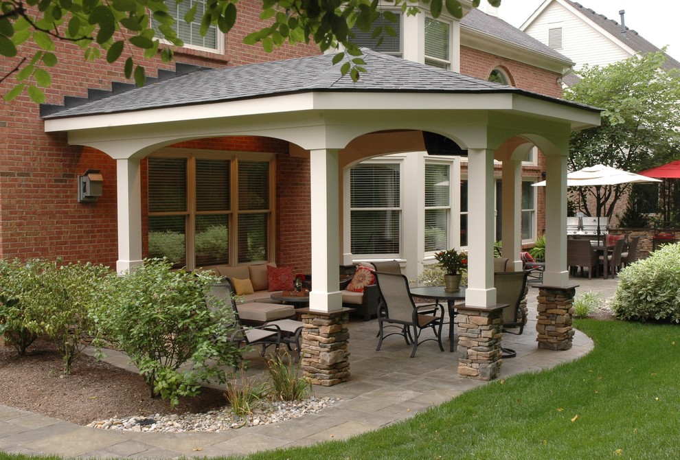 Foto de patio clásico de tamaño medio en patio trasero y anexo de casas con brasero y suelo de hormigón estampado