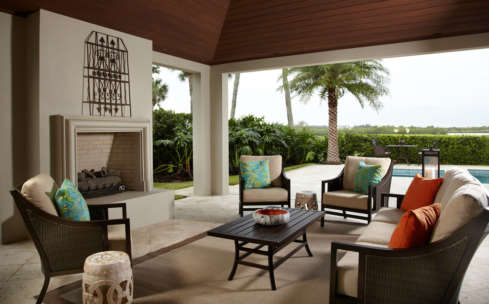 Large traditional back patio in Miami with a fire feature and natural stone paving.