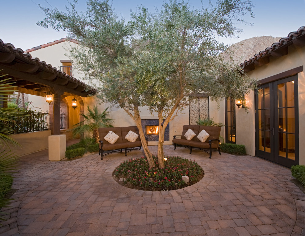 This is an example of a mediterranean courtyard patio in Orange County with a fire feature.