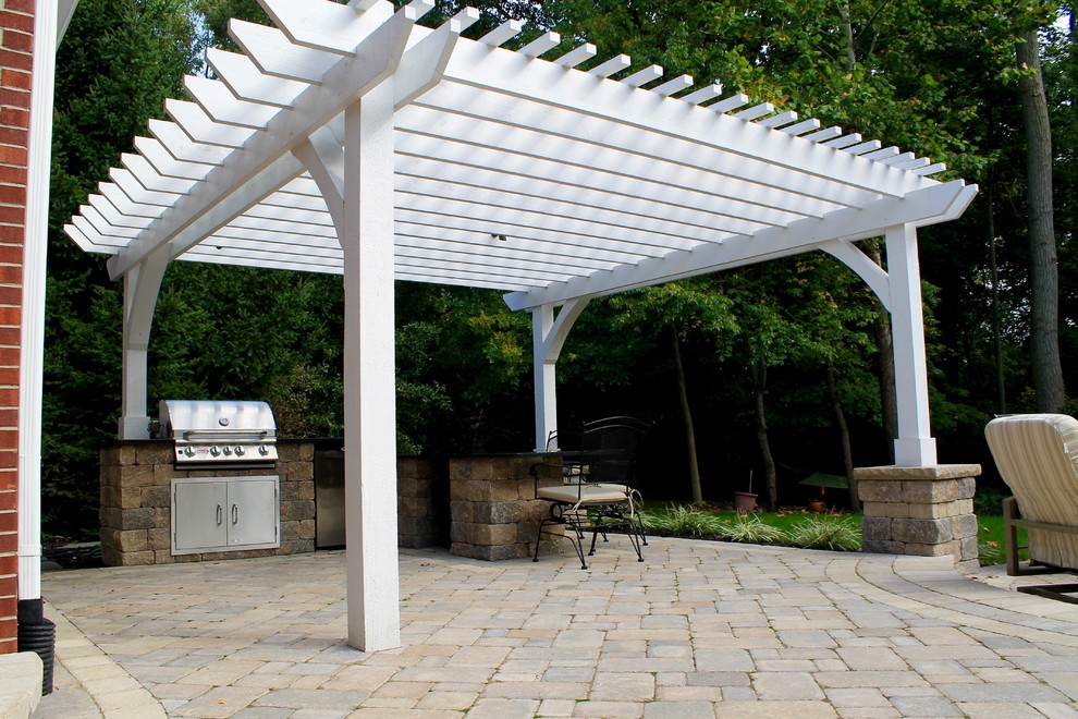 Design ideas for a large traditional back patio in Indianapolis with a fire feature, concrete paving and a pergola.