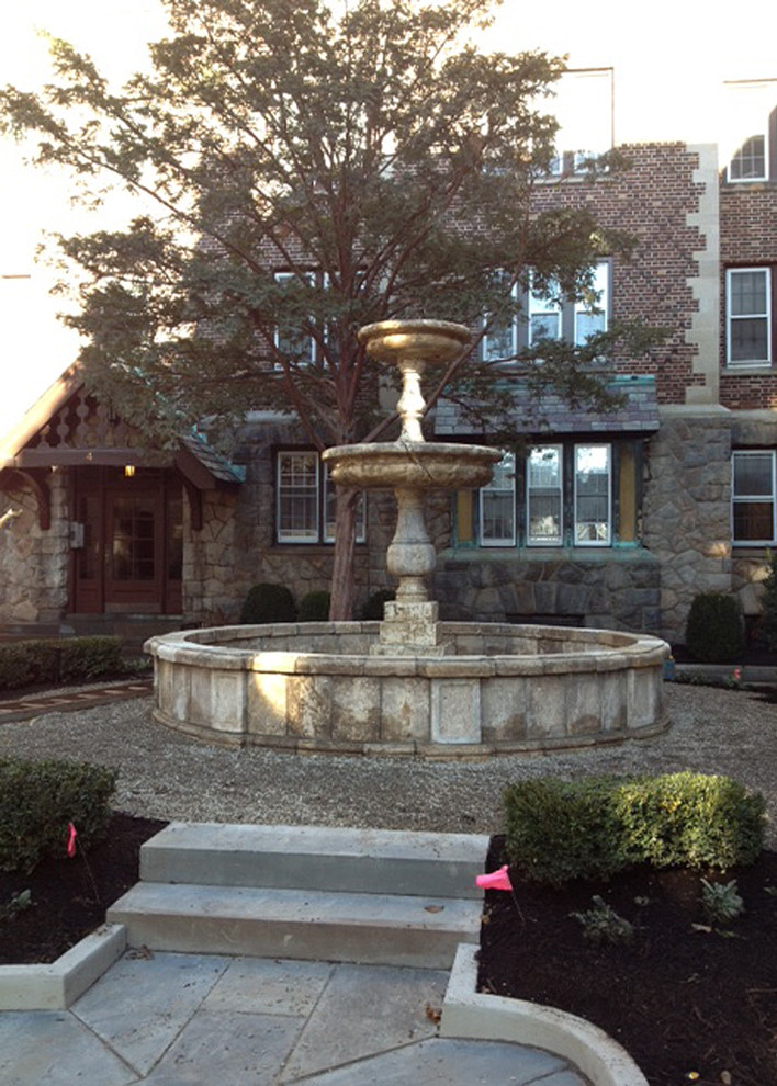Photo of a medium sized mediterranean courtyard patio in New York with a water feature, natural stone paving and no cover.