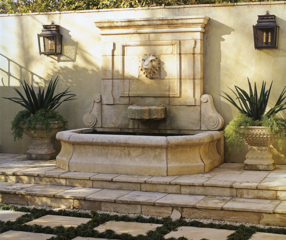 Imagen de patio mediterráneo de tamaño medio sin cubierta en patio con fuente y adoquines de piedra natural