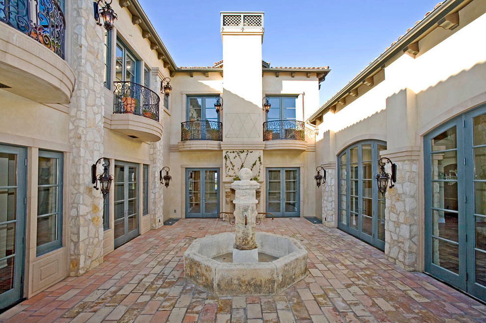 Foto di un patio o portico mediterraneo di medie dimensioni e in cortile con fontane, pavimentazioni in pietra naturale e nessuna copertura