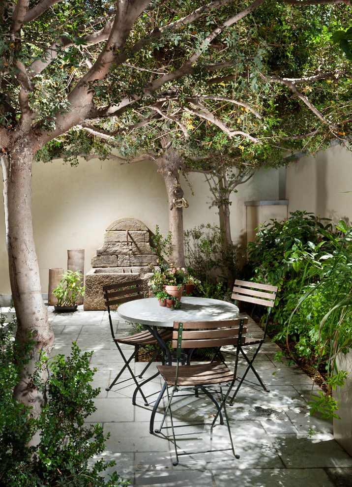 Inspiration for a medium sized mediterranean courtyard patio in New York with a water feature, natural stone paving and no cover.