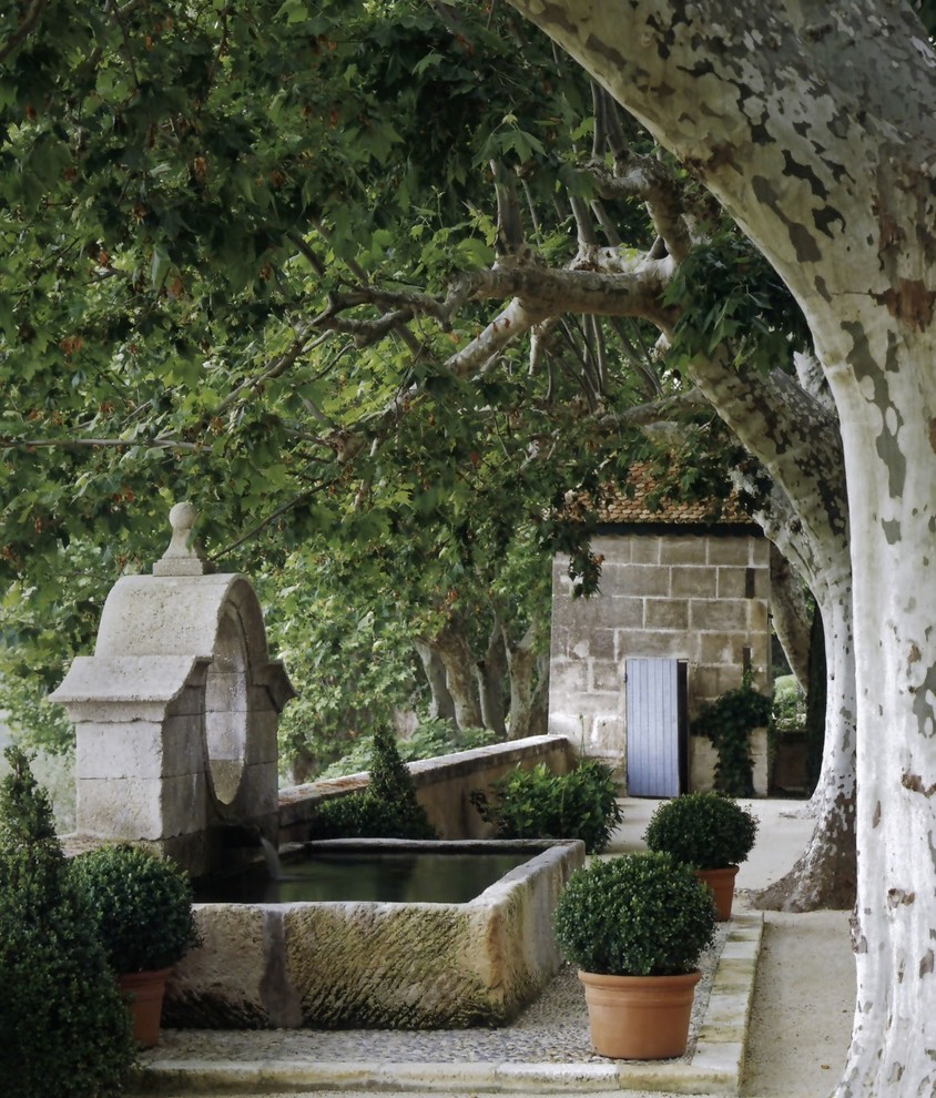 Photo of a medium sized mediterranean courtyard patio in New York with a water feature, natural stone paving and no cover.