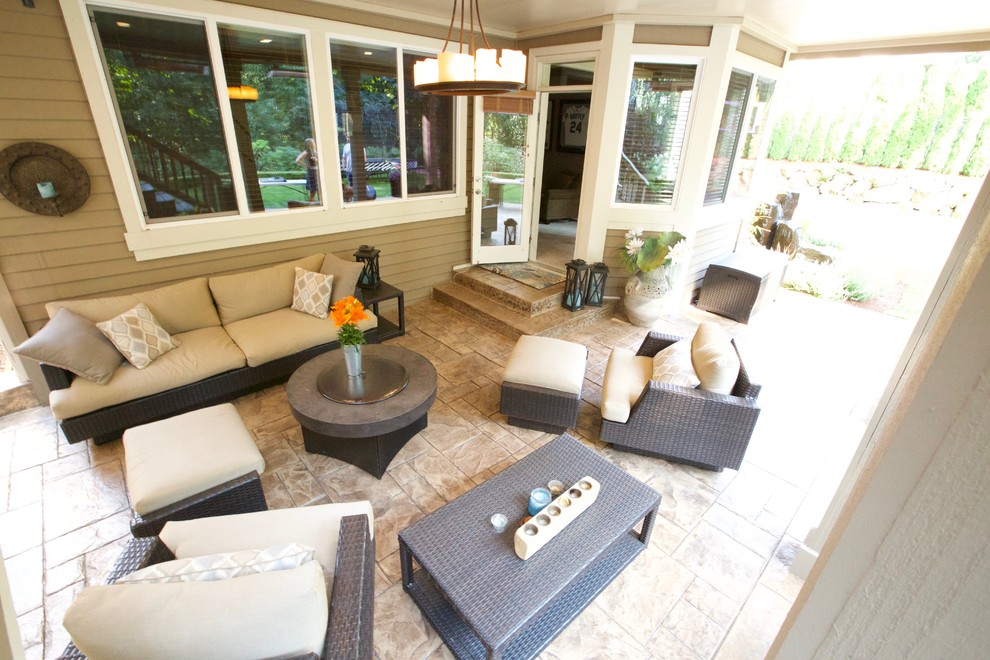 This is an example of a large modern back patio in Seattle with natural stone paving and a roof extension.