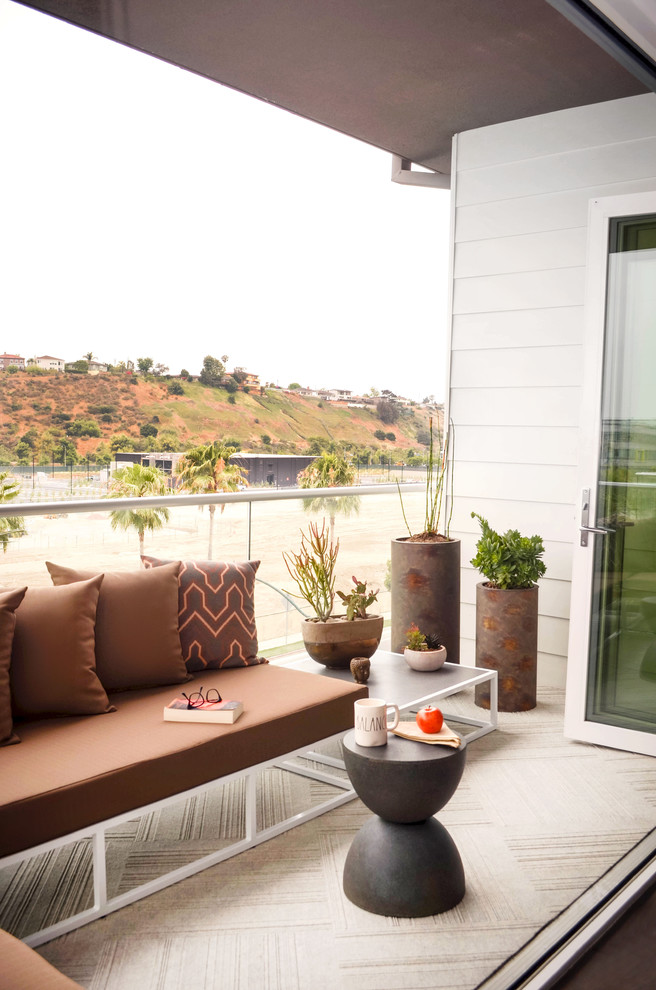Inspiration for a mid-sized contemporary concrete patio remodel in Los Angeles with a roof extension