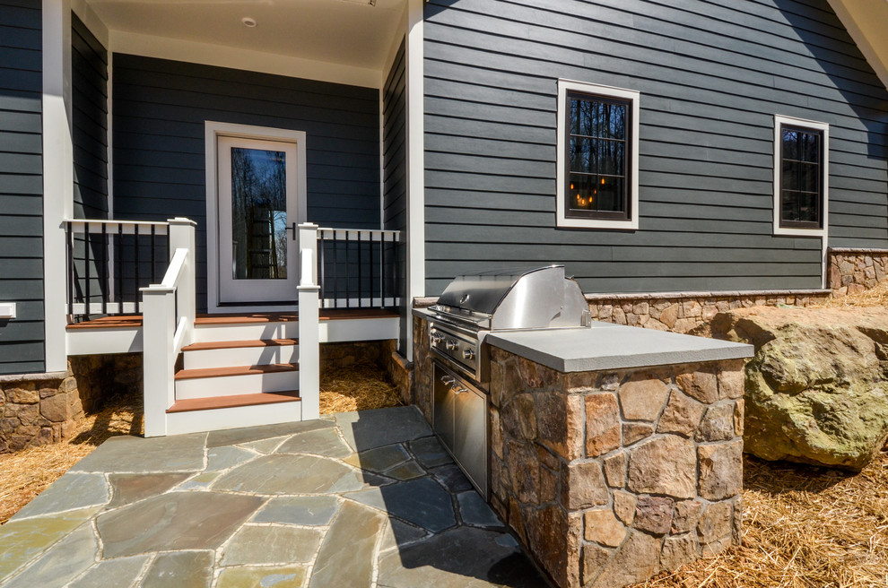 Modelo de patio campestre grande sin cubierta en patio lateral con cocina exterior y adoquines de piedra natural