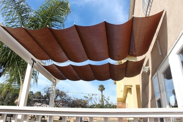 Immagine di un patio o portico minimalista di medie dimensioni e dietro casa con un parasole