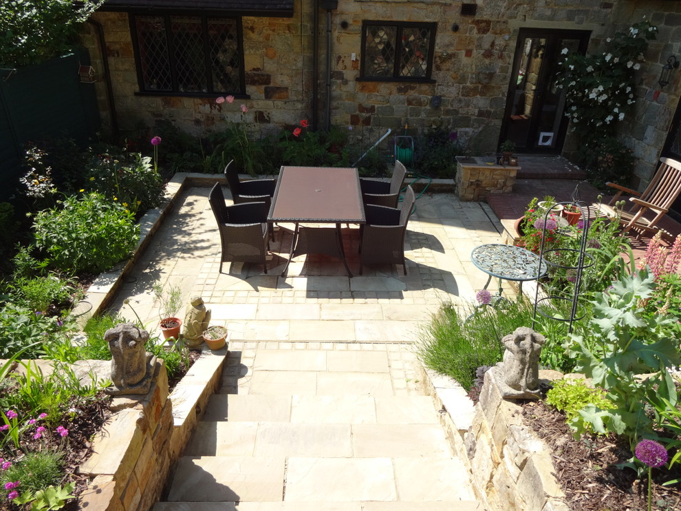 Inspiration for a medium sized traditional back patio in Sussex with natural stone paving.