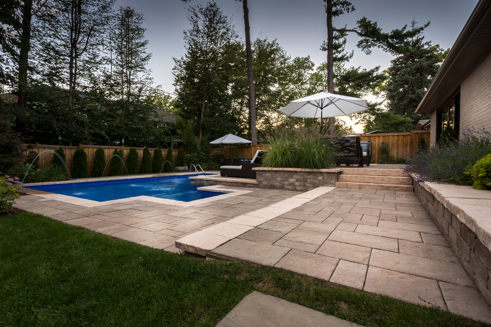 Inspiration for a mid-sized contemporary backyard stone patio remodel in Toronto with no cover