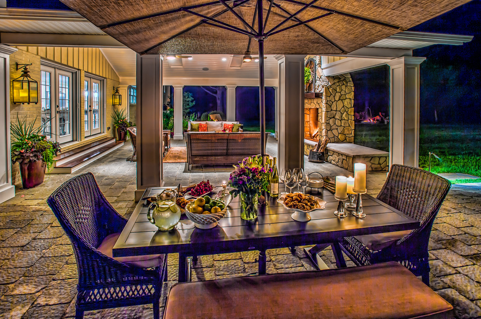 Foto de patio clásico de tamaño medio en patio trasero y anexo de casas con brasero y adoquines de ladrillo