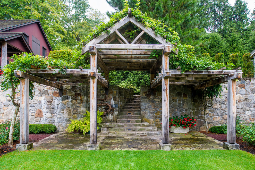 Foto di un ampio patio o portico minimal dietro casa con pavimentazioni in pietra naturale