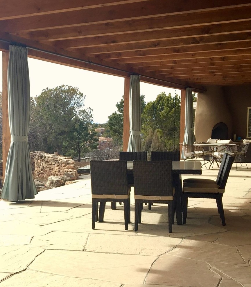 Imagen de patio de estilo americano grande en patio trasero y anexo de casas con chimenea y adoquines de piedra natural