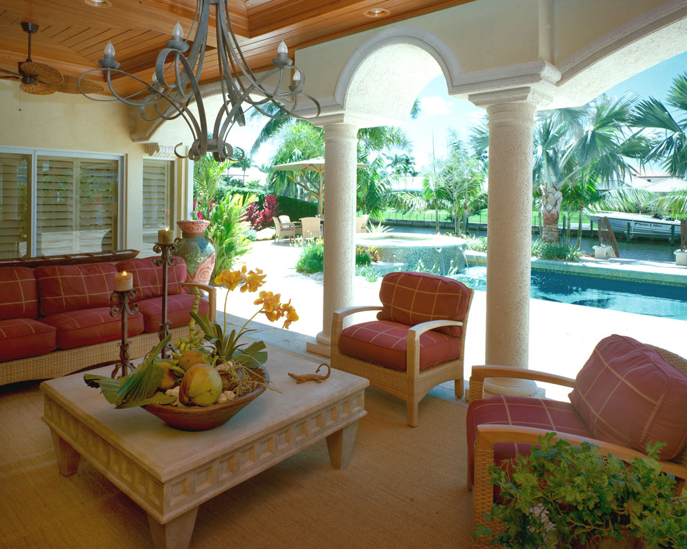 Foto di un patio o portico tropicale di medie dimensioni e dietro casa con pavimentazioni in cemento e un parasole