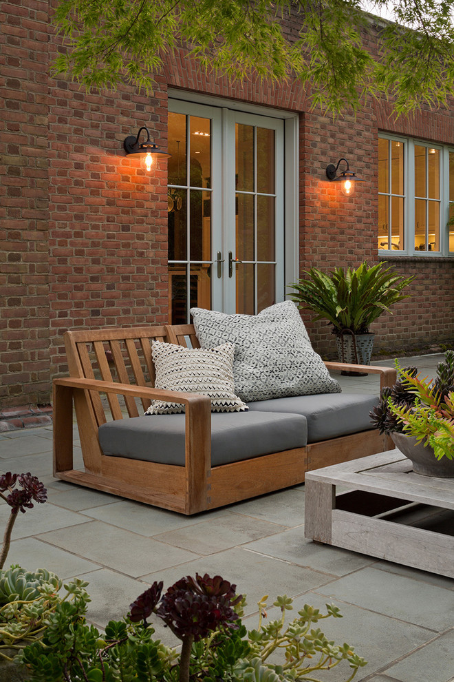 Immagine di un patio o portico minimal di medie dimensioni e dietro casa con piastrelle e nessuna copertura