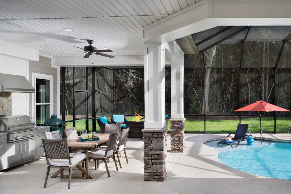 Huge transitional backyard concrete patio kitchen photo in Tampa with a roof extension