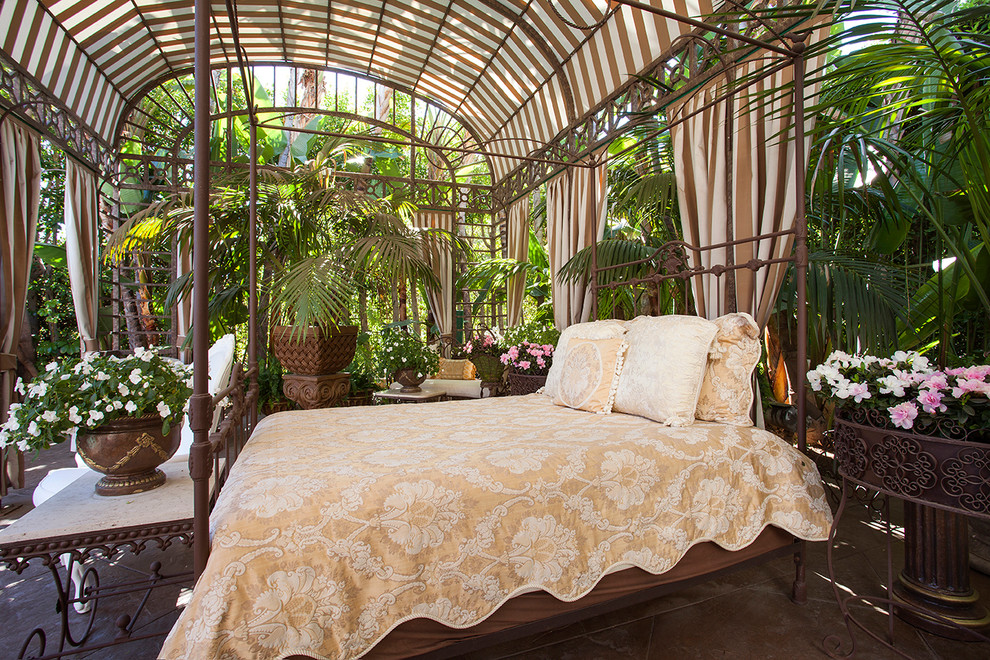 Ejemplo de patio tropical grande con losas de hormigón y cenador