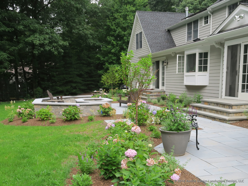 Foto de patio clásico sin cubierta en patio trasero con brasero y losas de hormigón