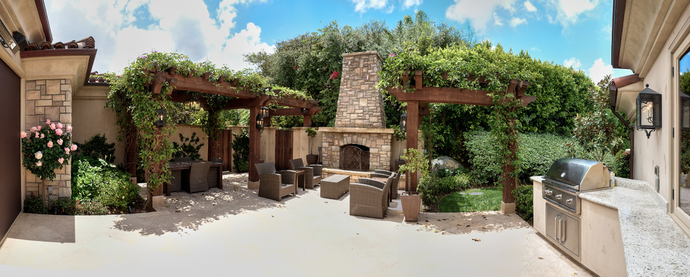 Medium sized mediterranean courtyard patio in San Diego with a fire feature, concrete slabs and a pergola.