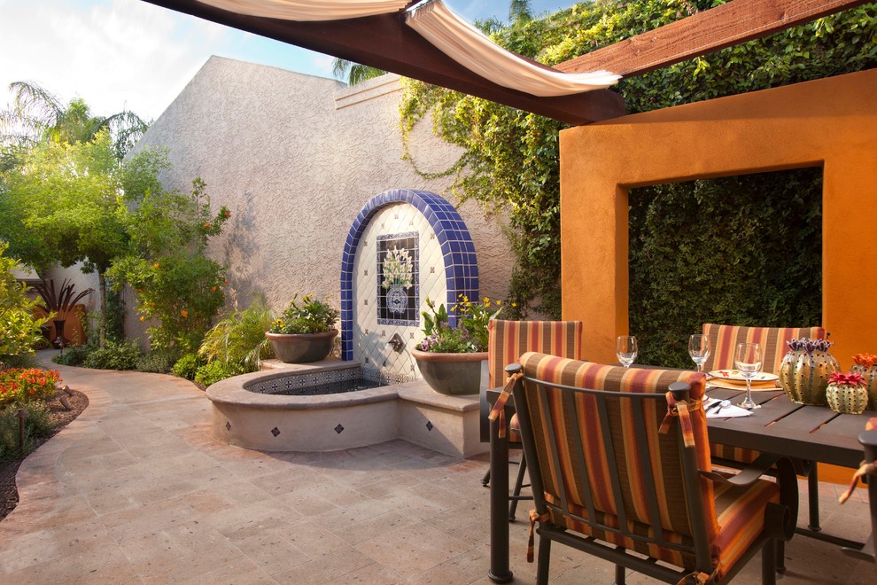 Inspiration for a mediterranean patio in Phoenix with a pergola and a water feature.