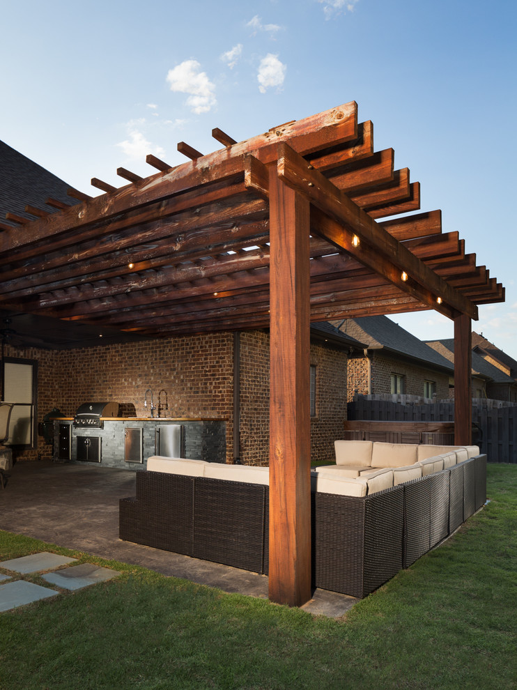 Cette photo montre une terrasse arrière montagne de taille moyenne avec une cuisine d'été, du béton estampé et une pergola.