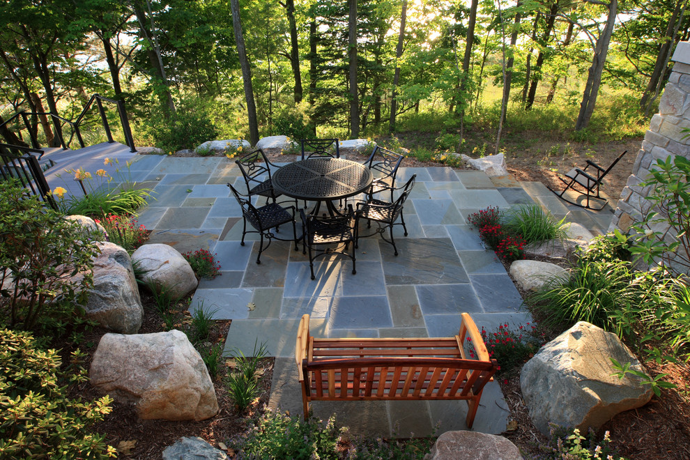 Ejemplo de patio tradicional grande sin cubierta en patio trasero con adoquines de piedra natural