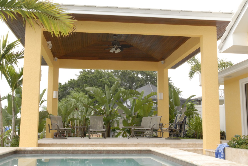 Immagine di un patio o portico tropicale dietro casa con un gazebo o capanno