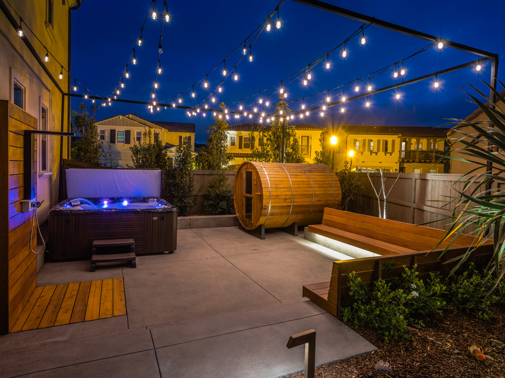 Moderner Patio hinter dem Haus mit Gartendusche und Betonplatten in San Diego