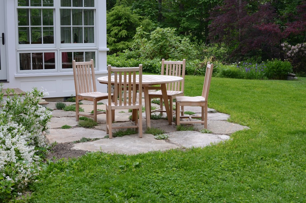 This is an example of a small classic back patio in Boston with natural stone paving and no cover.