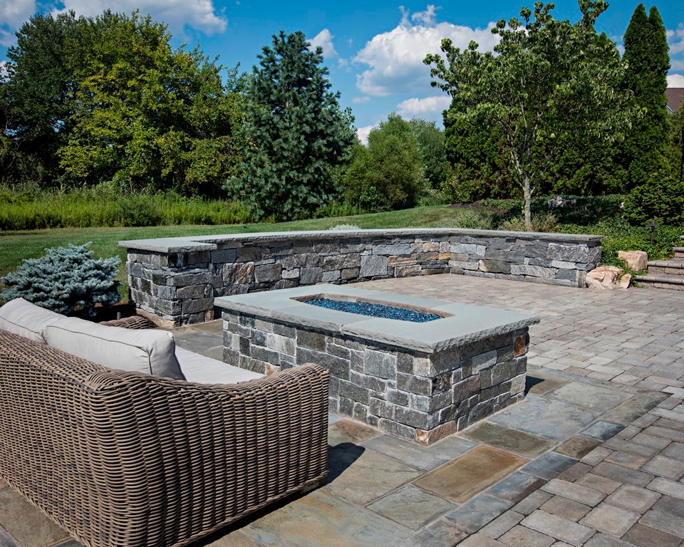 Diseño de patio clásico grande sin cubierta en patio trasero con brasero y adoquines de piedra natural