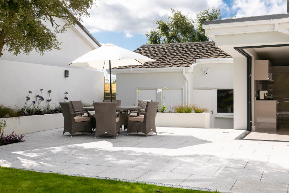 Inspiration pour une terrasse latérale design de taille moyenne avec une cuisine d'été et des pavés en pierre naturelle.