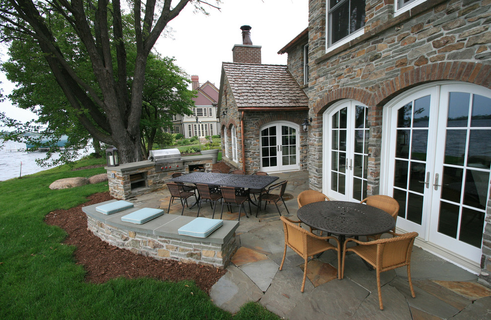 Exemple d'une terrasse arrière nature de taille moyenne avec une cuisine d'été, des pavés en pierre naturelle et aucune couverture.