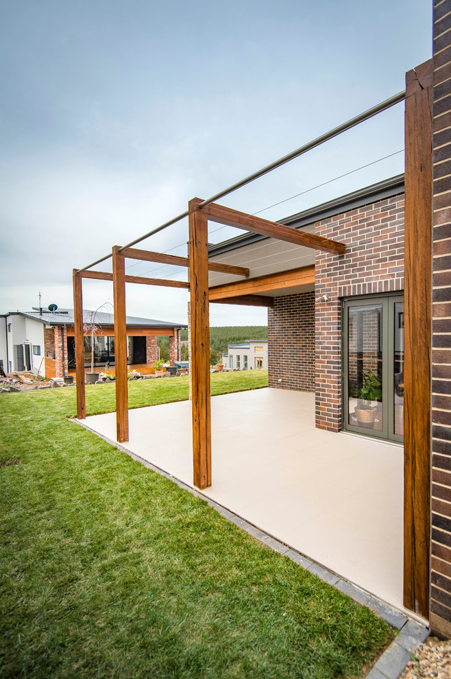Ejemplo de patio minimalista de tamaño medio sin cubierta en patio trasero con jardín vertical y suelo de baldosas