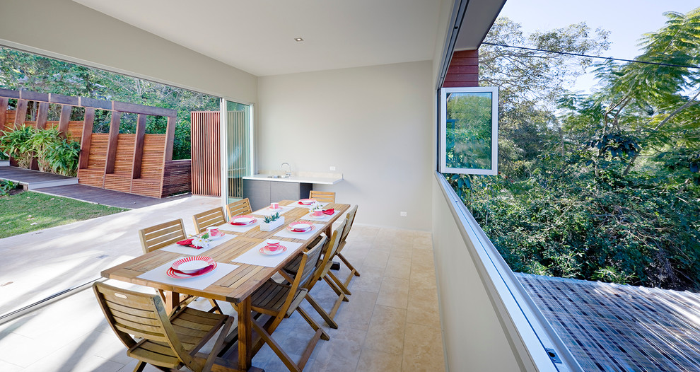 Идея дизайна: двор на заднем дворе в современном стиле с летней кухней, покрытием из каменной брусчатки и навесом