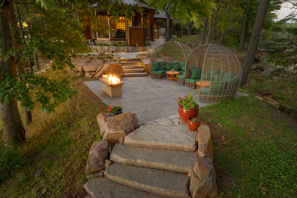 Foto de patio tradicional renovado extra grande en patio trasero con chimenea y adoquines de piedra natural