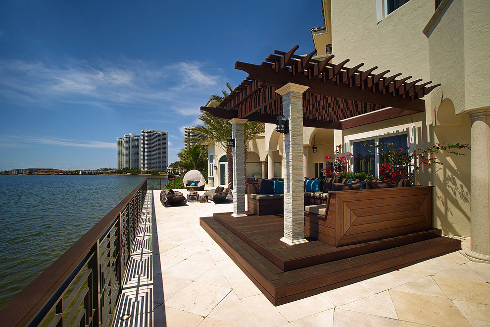 Design ideas for a large mediterranean back patio in Miami with a pergola.