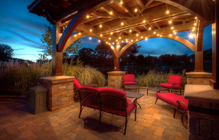 Inspiration for a large traditional back patio in Orange County with brick paving and a gazebo.