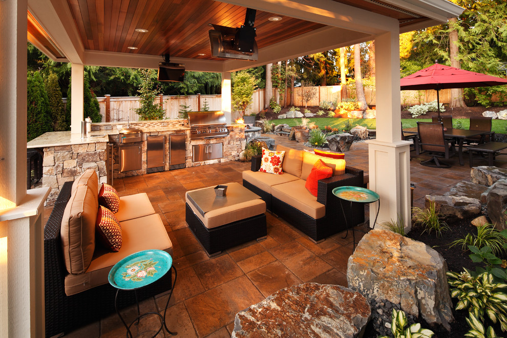 Cette photo montre une grande terrasse arrière tendance avec une cuisine d'été, des pavés en pierre naturelle et un gazebo ou pavillon.