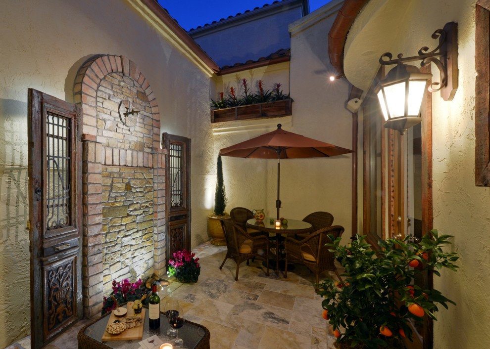 Photo of a small mediterranean courtyard patio in San Diego with tiled flooring and no cover.