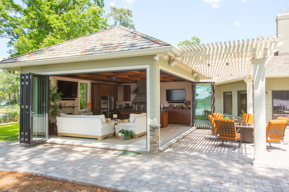 Immagine di un grande patio o portico stile americano dietro casa con un focolare, pavimentazioni in pietra naturale e una pergola