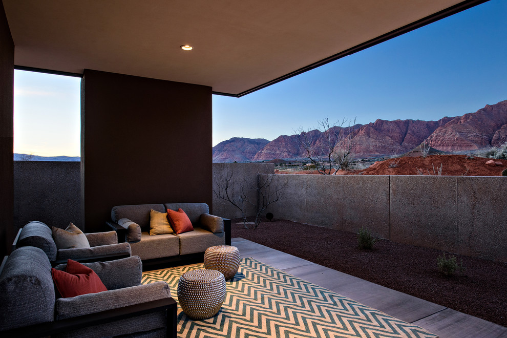Cette photo montre une terrasse tendance de taille moyenne avec une dalle de béton et une extension de toiture.