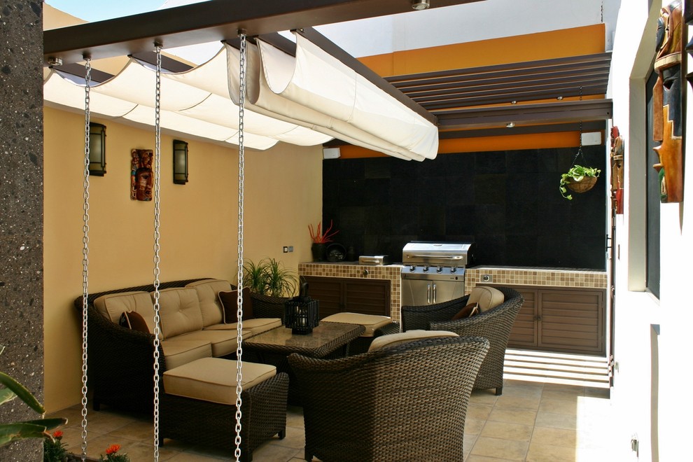 Inspiration for a small modern back patio in Other with an outdoor kitchen, tiled flooring and an awning.