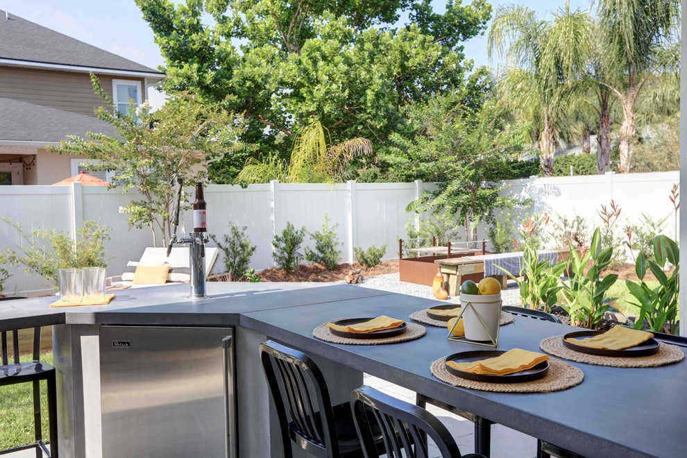 На фото: двор среднего размера на заднем дворе в современном стиле с летней кухней, мощением тротуарной плиткой и навесом