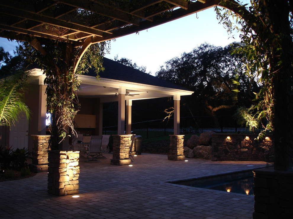 Diseño de patio exótico grande en patio trasero con adoquines de hormigón y pérgola